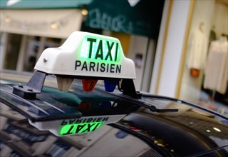 Sign of a Parisian taxi reflected in the roof