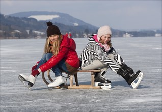 Young happy girls ice skating at a lake