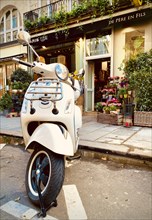 Scooter parked in front of flower shop