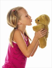 Little girl caresses her teddy bear