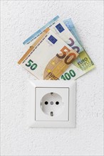 Socket with euro banknotes electricity