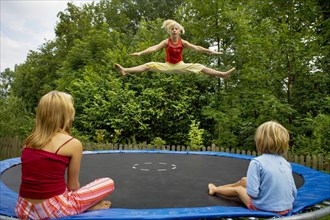Girls jumping on the trampoline in the garden