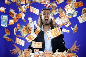 Young man throws banknotes into the air