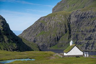 Small church with grass roof in mountain landscape