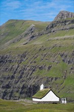 Small church with grass roof in mountain landscape