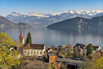 Holiday destination on Lake Lucerne with the parish church of St. Mary behind the snow-covered Alps