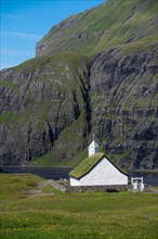 Small church with grass roof in mountain landscape