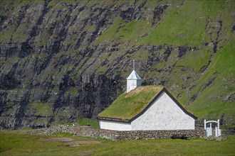Small church with grass roof in mountain landscape