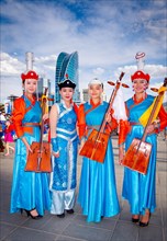 Mongolian girls wearing traditional costume and posing with national music instrument Morin huur