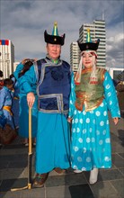 Mongolian couple is posing worn traditional costumes at the Sukhbaatar square