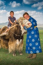 Nomadic woman hugging the head of yak