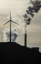 Wind turbine and smoking chimneys at the Uniper coal-fired power plant Scholven
