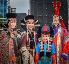 Young females wearing Mongolian traditional costumes and posing in the Central square during the DEEL festival