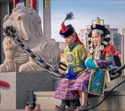 Mongolian boy in the traditional traditional traditional traditional traditional traditional traditional traditional traditional traditional costume of a man and a girl in the traditional costume of a...