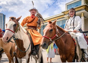 Horse ridership with trained falcon posing in front of Parliament house of Mongolia