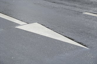 Directional arrow on rain wet road
