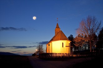 Illuminated Rochuskapelle on the Steltenberg in the evening with full moon