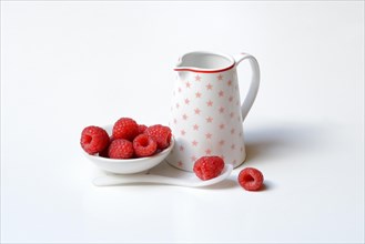 Bowl with raspberries and milk jug