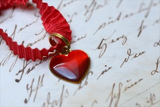 Pendant with heart on letter paper with old writing