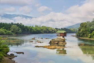 Wooden house on rocks in the river Drina