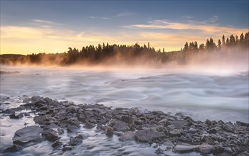 Autumn atmosphere with fog on the river in the evening light