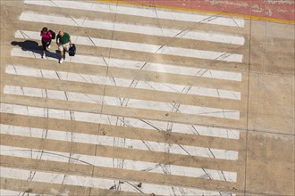 Top view of traveling couple walking on crosswalk