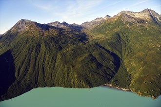 Steep forested mountainsides and an emerald green lake