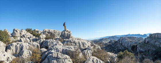 Young man standing on rocks and looking into the distance