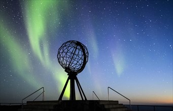 Steel globe at North Cape with northern lights