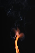 Smoke from a burnt match against a dark background