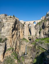Bridge Puente Nuevo with waterfall at steep cliffs