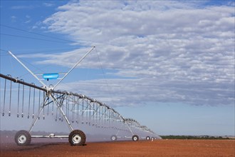 Pivot Sprinklers spread water on cotton harvested fields