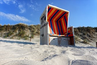 Colorful wicker beach chair on a sandy beach