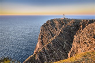 North Cape cliff with steel globe in the light of the midnight sun