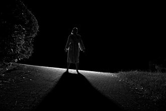 Woman in bathrobe on her way in the night