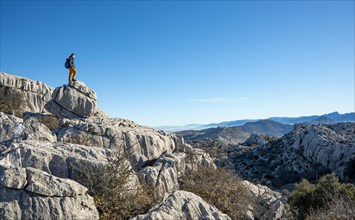 Young man standing on rocks and looking into the distance