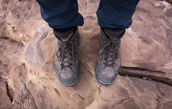 Brown hiking boots on rocky ground