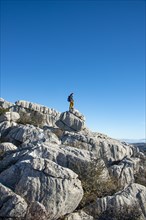 Young man standing on rocks and looking into the distance