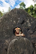 Native of Yap looks through stone money hole