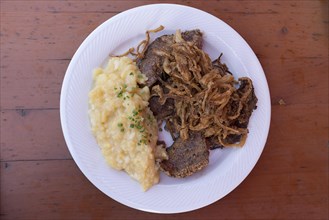 Roasted liver with fried onion and potato salad served in a Franconian beer garden