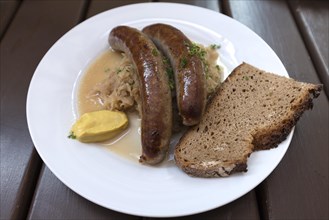 Franconian sausages with sauerkraut and bread served in a beer garden