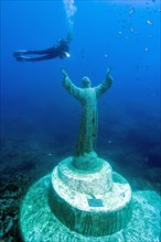 Diver at Christ statue under water