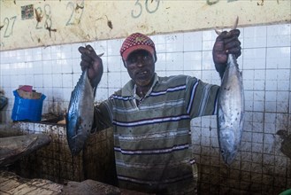 Somali man offering his fish in the Fishmarket