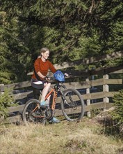 Mountain biker in her late forties on e-MTB rides on forest tracks