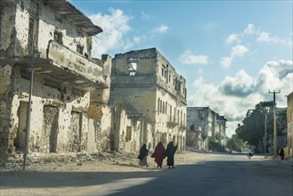 Somali women walking through the streets of the destroyed houses of Mogadishu