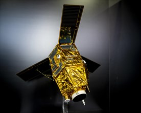 Model of a satellite with solar panel and golden heat protection foil