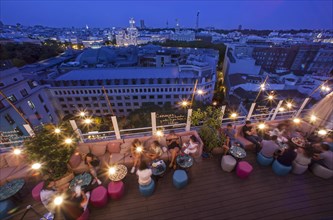 Groups and couples enjoy a summer night at the terrace bar of Casa Suecia Hotel in Madrid