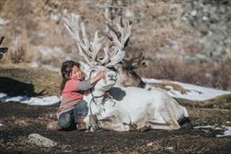 Reindeer herder girl with baby reindeer. Ulaan taiga mountains. Khuvsgul province