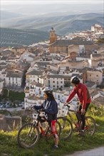 Two mountain bikers observe the village of Cazorla