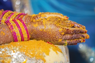 Hindu Bride crossing hands painted with henna for prayer on wedding eve